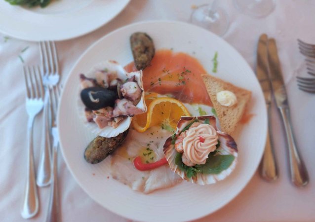 Piatto di pesce con salmone, polpo e decorazioni.