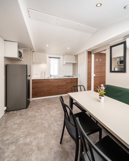 Cucina moderna con tavolo e sedie nere.