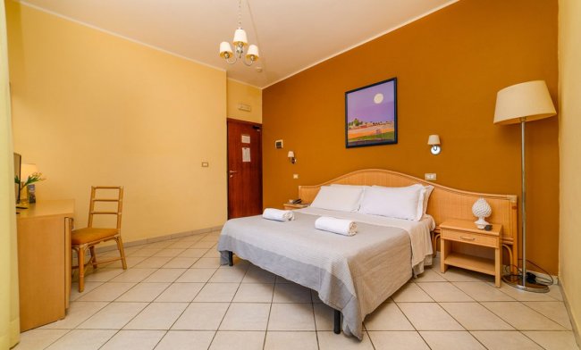 Camera matrimoniale con pareti gialle e arancione.