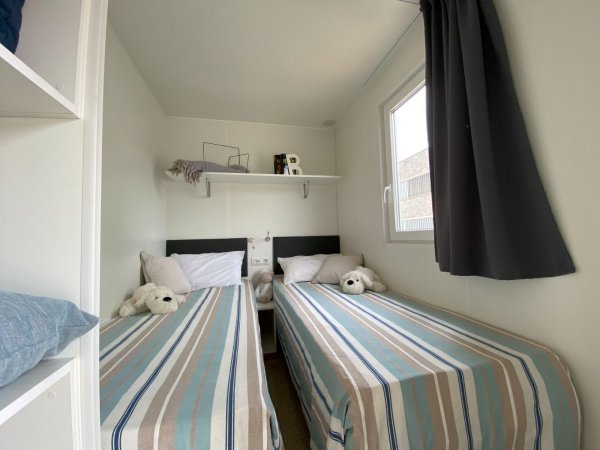 Cameretta con due letti singoli e peluche.