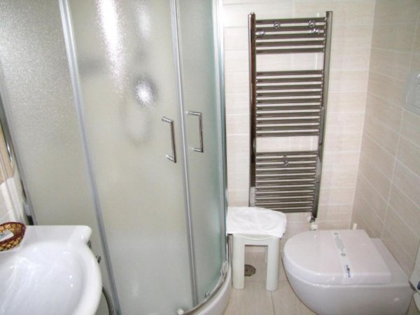 Bagno con cabina doccia, lavabo e scaldasalviette.