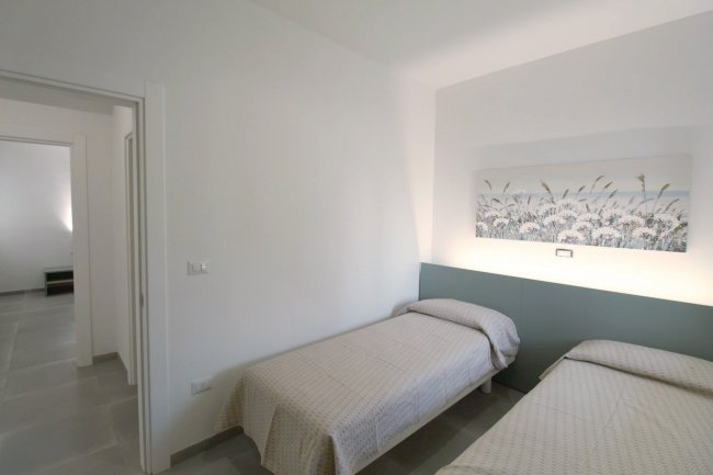 Camera con due letti singoli e un quadro floreale.