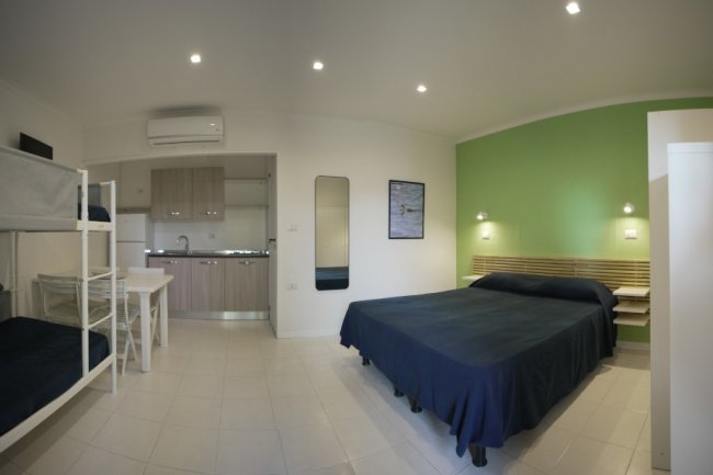 Camera con letto matrimoniale, letto a castello, cucina.