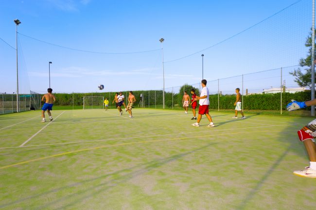 Giovani giocano a calcio su un campo all'aperto.
