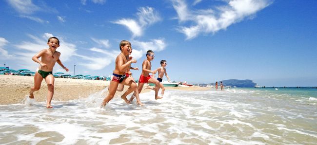 Bambini che corrono in mare su una spiaggia.