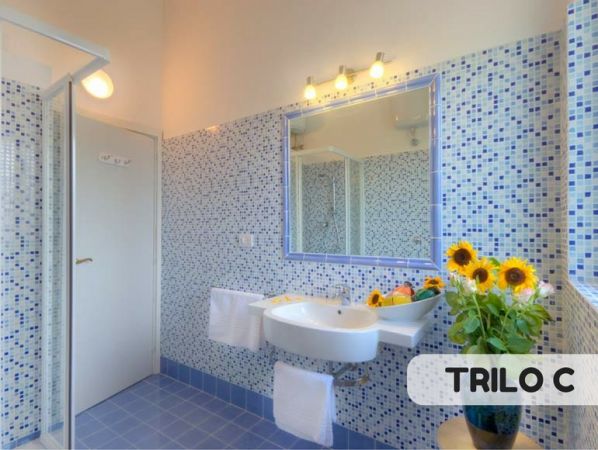 Bagno con piastrelle blu e fiori gialli.