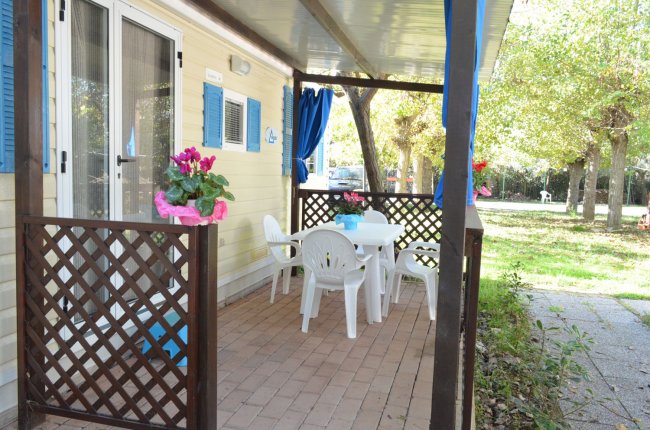 Veranda con tavolo e sedie in plastica bianca.